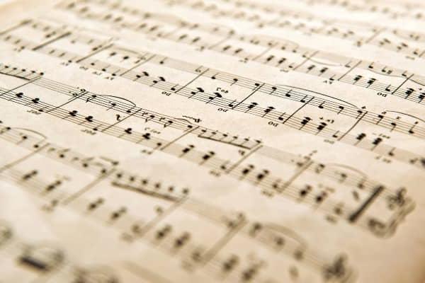 A piece of white sheet music with black musical bars and notes on it. The image has an angled, upside-down view.